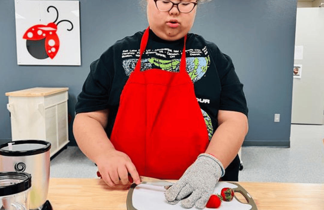 Jensen cuts strawberries on a cutting board.