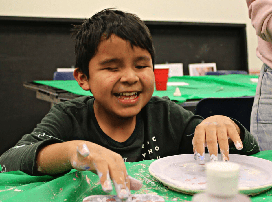 Alexis is giggling as he works on an art craft.