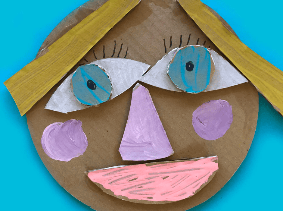 Image shows a girls' face made out of cardboard cut outs.
