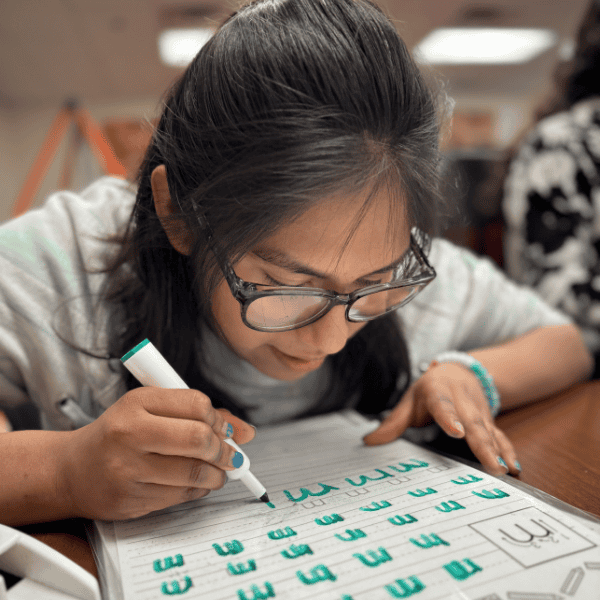 A student practices writing the letter m.